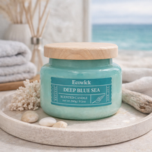 Load image into Gallery viewer, Ecowick Deep Blue Sea scented soy candle styled with coastal decor and wooden lid
