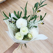 Load image into Gallery viewer, Bouquet of white flowers with green leaves on a wooden surface
